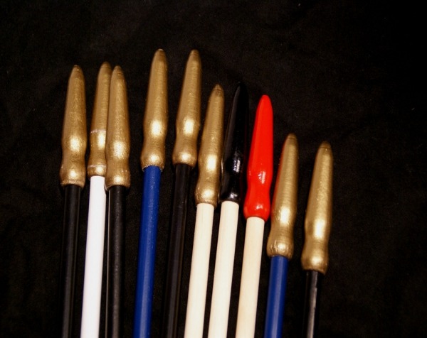 Painted wooden flag dowels with spear tips, available in bulk for high-volume manufacturing.